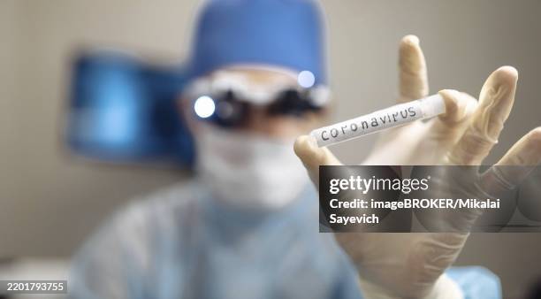 scientist holding coronavirus test tube, dressed in protective laboratory gear - lateral flow test stock pictures, royalty-free photos & images