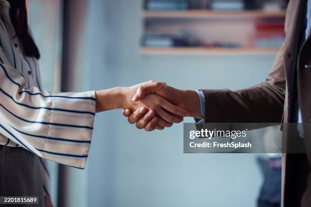 close-up of professional handshake in modern workplace setting - reliable bildbanksfoton och bilder
