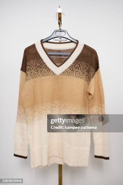a tan and white sweater with a brown stripe - oberteil stock-fotos und bilder