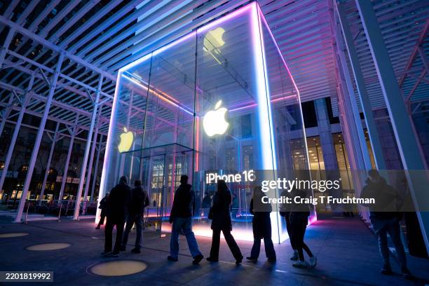 People walk by the Apple Store on Fifth Avenue during sunset on February 24, 2025 in New York City.