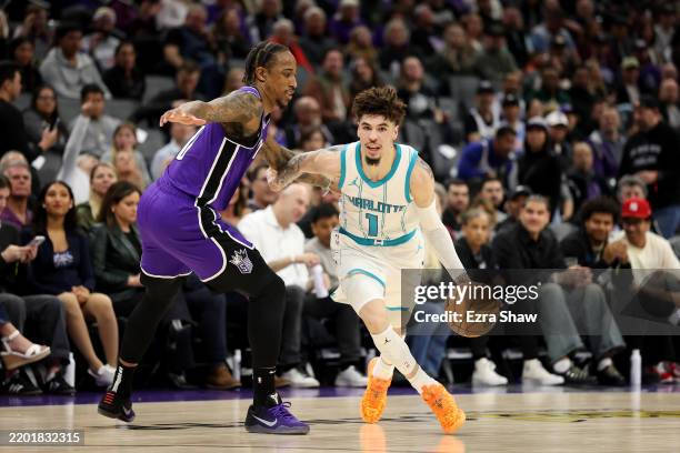 LaMelo Ball of the Charlotte Hornets is guarded by DeMar DeRozan of the Sacramento Kings during the first half at Golden 1 Center on February 24,...