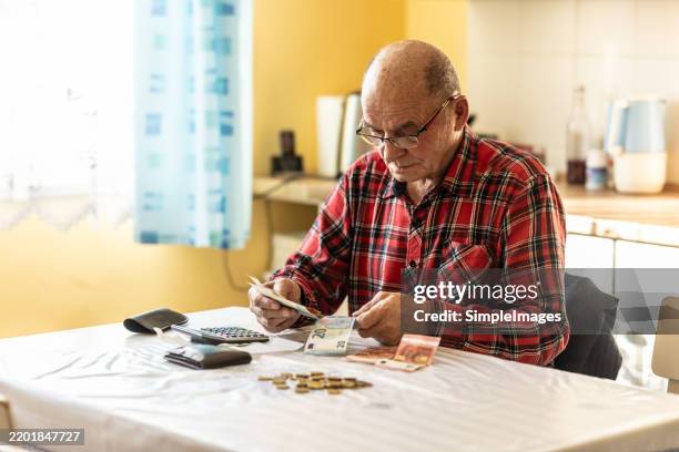 close-up of a senior man counting money in european union currency - armoede stockfoto's en -beelden