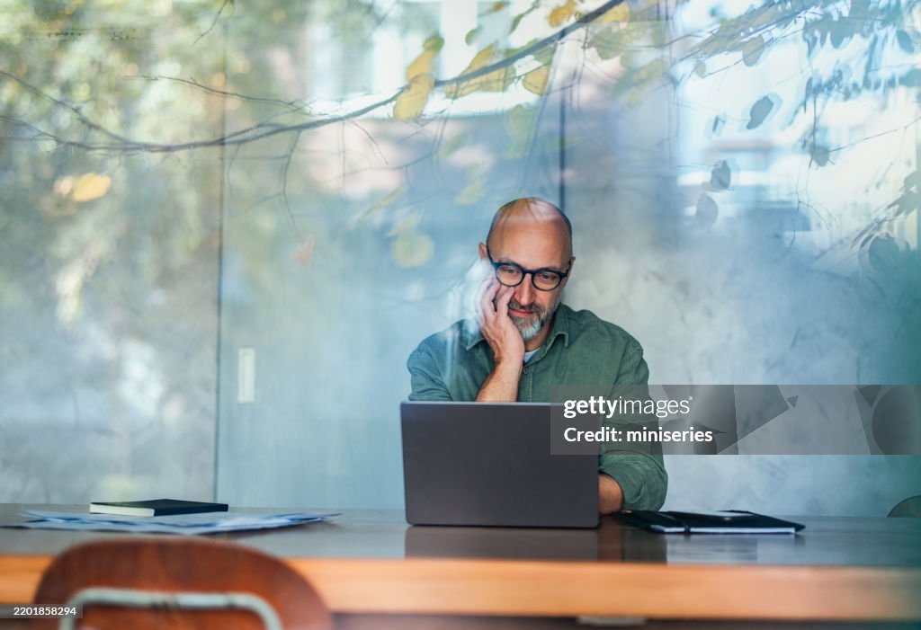 Businessman Working on Laptop in a Modern, Well-Lit Office Environment