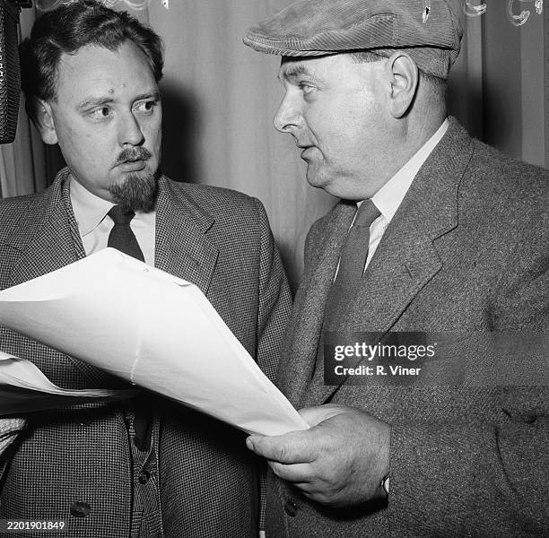 Actors Norman Pointing and Bob Arnold, right, hold their scripts during a performance of radio drama "The Archers", February 26th 1957.