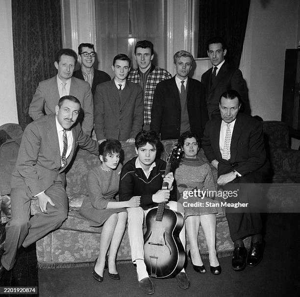 Pop musician Cliff Richard, seated holding guitar, with clockwise from rear left: chauffeur Joe Lee, guitarist Hank Marvin, drummer Tony Meehan,...