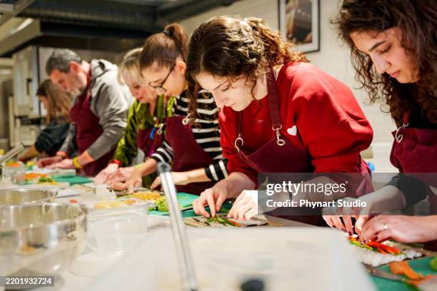 participants engaged in a hands-on sushi-making class - cooking class stock pictures, royalty-free photos & images