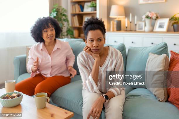 tense female friends arguing at home - negative emotion stock pictures, royalty-free photos & images