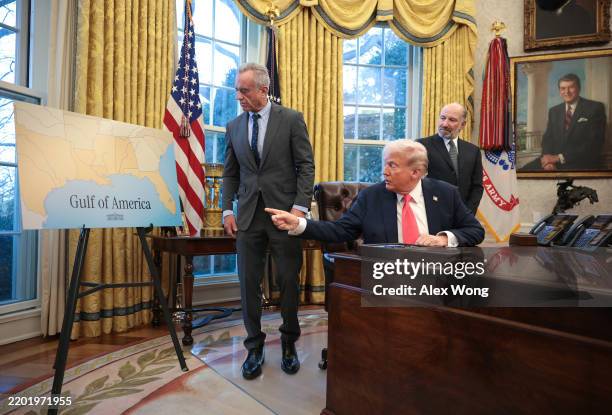 President Donald Trump, joined by Health and Human Services Secretary Robert F. Kennedy Jr. And Commerce Secretary Howard Lutnick , refers to a chart...