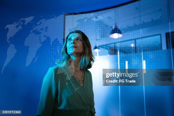 mujer de negocios madura que busca un holograma en la oficina - holographic-map fotografías e imágenes de stock