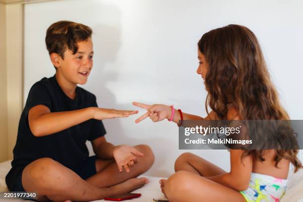kids playing rock-paper-scissors and having fun - tesoura papel pedra imagens e fotografias de stock