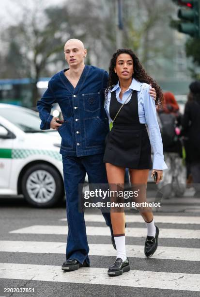 Adam wears silver necklace, buttoned denim jean Gucci jacket, navy blue flared denim jean Gucci pants, shiny loafer moccasin Gucci leather shoes....