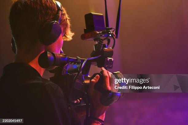young videographer filming live event – professional camera operator on movie or tv stage - filmar imagens e fotografias de stock