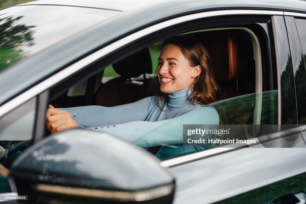 Young woman buying her first car. First-time car owner concept.