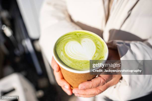 people enjoy drinking delicious matcha tea / latte coffee with green foam. - matcha stock-fotos und bilder
