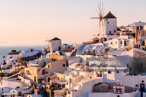 oia village townscape with traditional greek windmills at sunset, santorini island, greece - santorini stock pictures, royalty-free photos & images