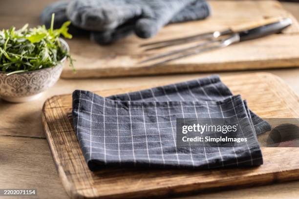 new plain pattern kitchen towel folded on cutting board. kitchen towel or textile napkin. free space for your product or groceries. - napkin stock pictures, royalty-free photos & images