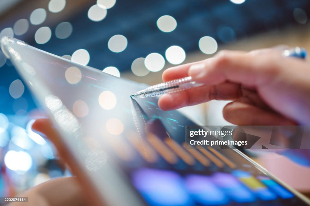 Business professional reviewing financial data with holographic market analytics data trends with a digital overlay