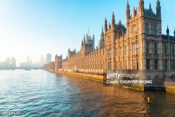 palacio de westminster reflejado en el río támesis al atardecer - casas del parlamento westminster fotografías e imágenes de stock