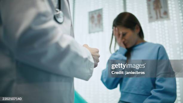 female doctor delivers difficult news to a female patient about her health status - patient bad news stock pictures, royalty-free photos & images