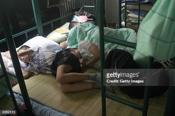 Male students sleep in their dormitory before the beginning of their daily training at the state owned Shichahai sports school July 25, 2003 in...