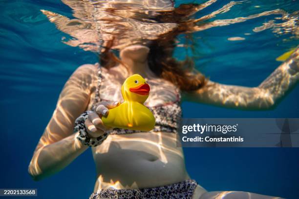 yellow rubber duck toy in the sea - rubber band tension stock pictures, royalty-free photos & images