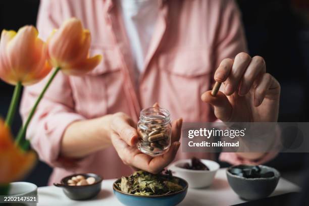 holding herbal capsules in a hand - alternative lifestyle stock pictures, royalty-free photos & images