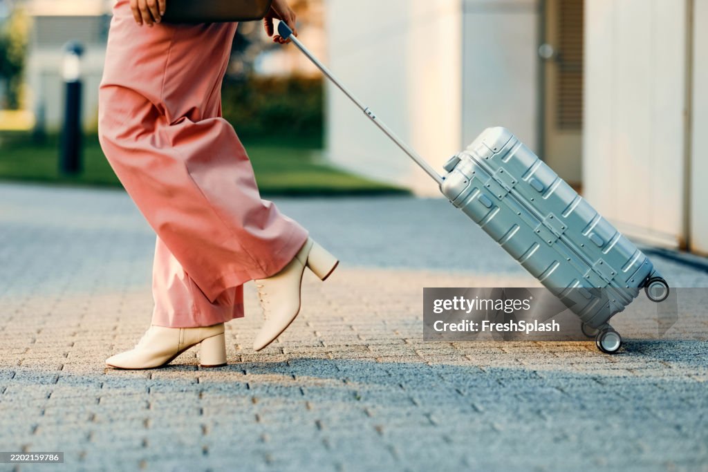 Young Traveler Walking with Stylish Suitcase Outdoors in an Urban Setting