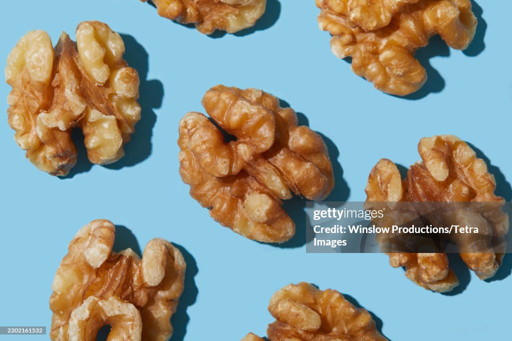 Overhead view of walnuts against blue background