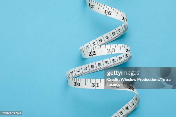 measuring tape on blue background - mètre à ruban photos et images de collection