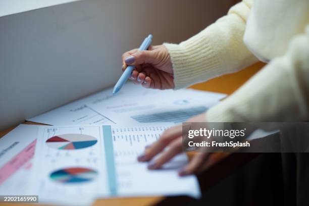 professional hands reviewing charts and graphs in an office setting - worksheet stock pictures, royalty-free photos & images