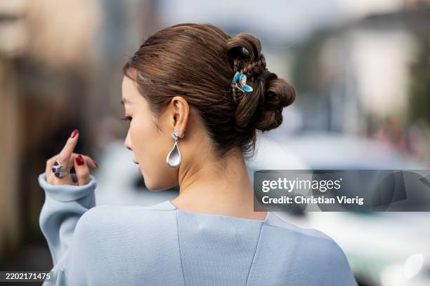 Angelene Sun wears hair clip, silver earrings outside Jil Sander during the Milan Fashion Week Womenswear Fall/Winter 2025/2026 on February 26, 2025...