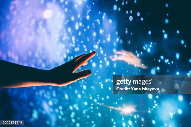 a human hand reaching out to the dark unknown, the dark matter - anticipation photos et images de collection