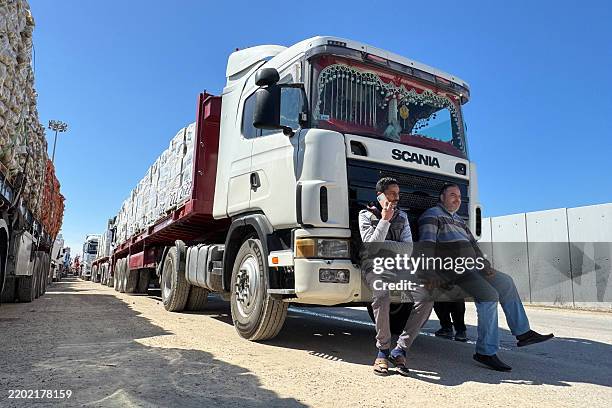 Trucks carrying humanitarian aid line up on the Egyptian side of the Rafah border crossing with the Gaza Strip on March 2 after Israel suspended the...