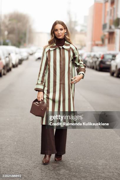 Cris Mata wears mint green and brown stripped coat, dark brown pants, brown shoes and brown bag outside the Vivetta fashion show during the Milan...