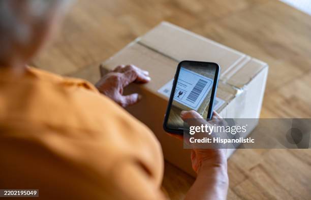 close-up on a woman scanning a code while mailing a package - parcel tracking stock pictures, royalty-free photos & images