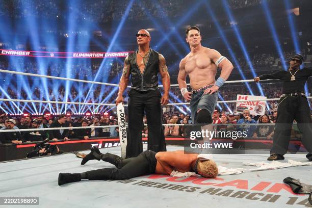 Dwayne "The Rock" Johnson, John Cena, and Travis Scott stand over Cody Rhodes during WWE Elimination Chamber at Rogers Centre on March 1, 2025 in...