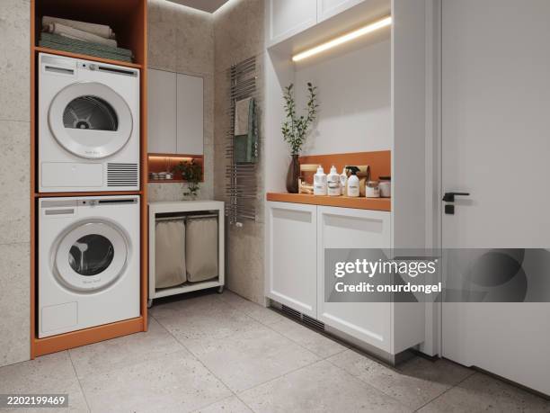 buanderie moderne avec lave-linge, sèche-linge, panier à linge et serviettes pliées dans l’armoire - buanderie photos et images de collection