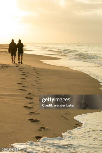 father and son walking on beach at sunset, cape cod - cape cod stock pictures, royalty-free photos & images