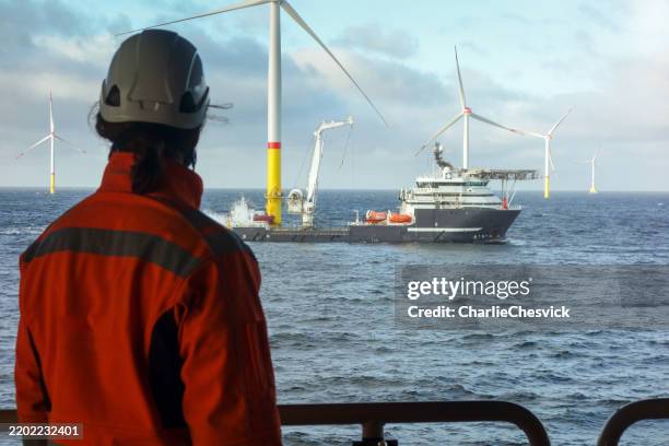 offshore wind farm operations – worker observing service vessels and wind farm from substation - oljeplattform bildbanksfoton och bilder