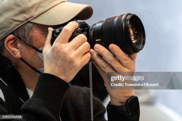 An attendee tries out a mirrorless digital camera in the Nikon booth during the CP+ 2025 show on February 27 in Yokohama, Japan. One of the world's...