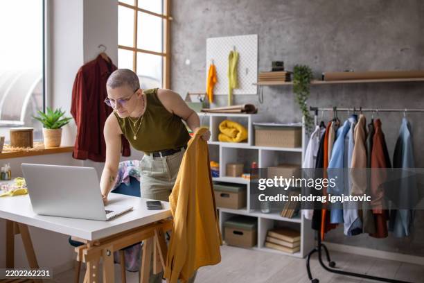 créateur de mode triant les vêtements pour la vente en ligne - industrie de la mode photos et images de collection