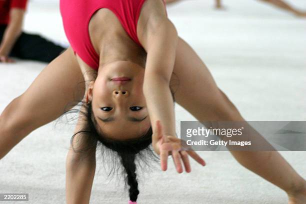 Young girl exercises during the daily training sessions at the state owned Shichahai sports school July 25, 2003 in Beijing, China. The school is one...