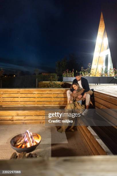couple passant une soirée romantique devant un foyer - emmitouflé dans une couverture photos et images de collection