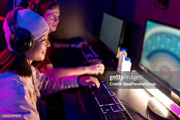 young gamers playing on computer in internet cafe - massively multiplayer online game stock pictures, royalty-free photos & images