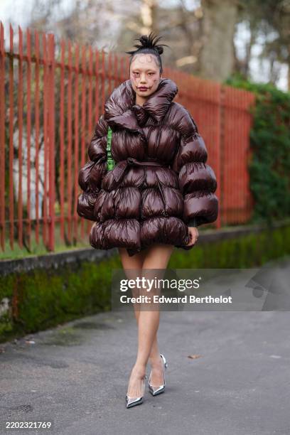 Guest wears dark brown slick back disheveled bun, burgundy bordeaux graphic face art, blond eyebrow, burgundy bordeaux lipstick, shiny burgundy...