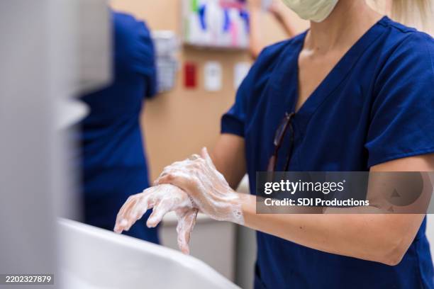 travailleur de la santé se lave les mains à l’eau et au savon - se frotter les mains photos et images de collection