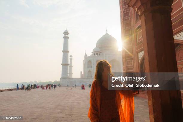 woman exploring taj mahal at sunrise, india - tadsch mahal stock-fotos und bilder