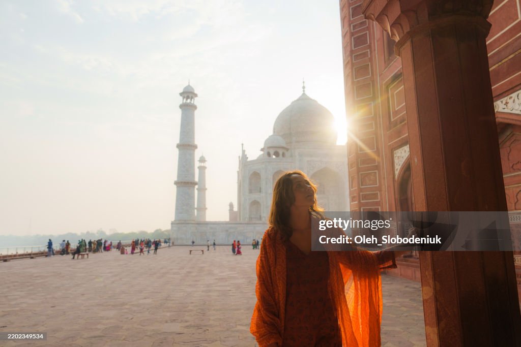 Woman exploring Taj Mahal at sunrise, India