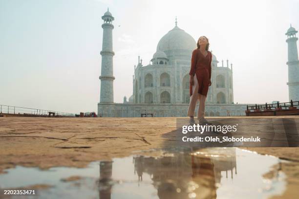 woman near taj mahal with reflection in water - tadsch mahal stock-fotos und bilder