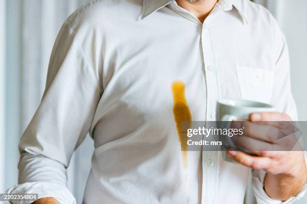 man spilling coffee on shirt - coffee stains stock pictures, royalty-free photos & images